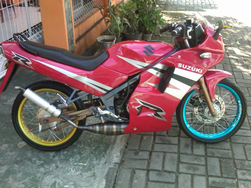 Ảnh bìa đẹp với xe máy Suzuki độ thể thao màu đỏ, tem đua nổi bật và bánh xe phối màu độc đáo