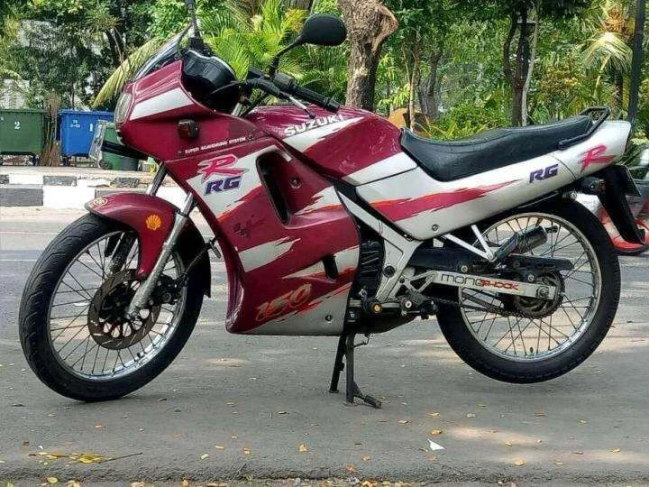 Ảnh bìa đẹp với xe máy Suzuki RG cổ điển màu đỏ trắng đỗ bên đường dưới hàng cây xanh