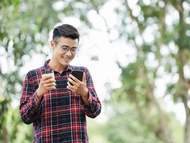 Nam thanh niên để kiểu tóc layer ngắn nam đẹp, trẻ trung khi dùng điện thoại